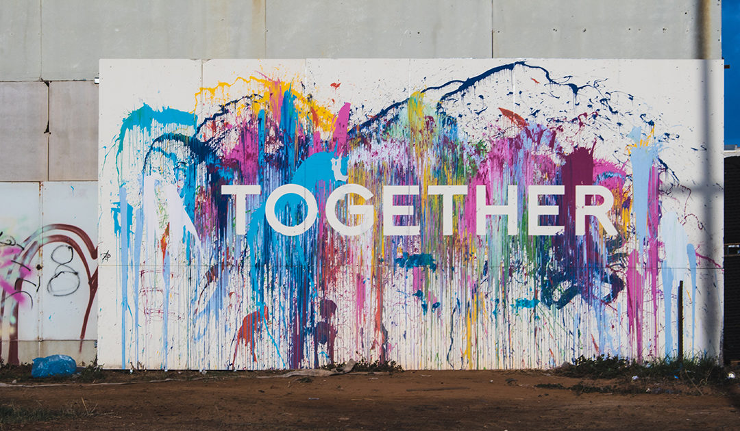 "Together" spray painted on a wall with graffiti